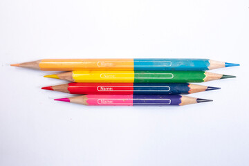 Used bi colour pencils isolated on white background. Small hole and name on the surface.
