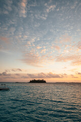 Naklejka na ściany i meble sunset over the sea with tiny tropical island