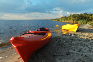 Beautiful modern kayaks on beach near river