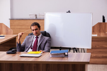 Young male business trainer in the office during pandemic