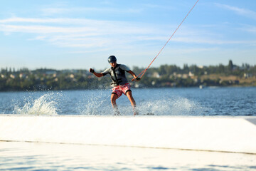 Teenage boy wakeboarding on river. Extreme water sport