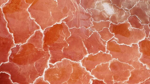 Cinematic overhead orange nature texture looks like meat or prosciutto ham. Beautiful scenic natural background 4K USA.Amazing red pattern top down aerial background with white salt surface texture