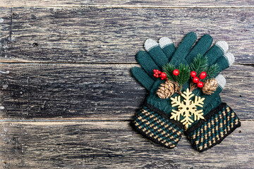 Winter gloves and pine cone on wooden background