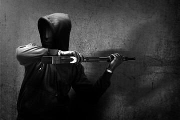 Criminal man in a hidden mask holding the shotgun