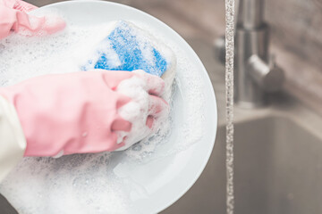 washing a plate with a sponge in the sink