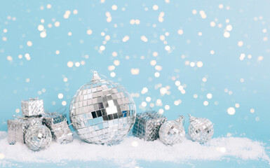 Christmas toy disco ball slugs on pastel blue background, snow sparkles, confetti. Christmas or New Year mockup concept