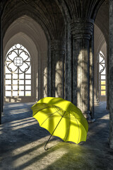 An open bright yellow umbrella on the floor in a large hall with Gothic columns. 3d illustration