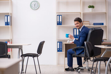 Young male employee drinking coffee during break