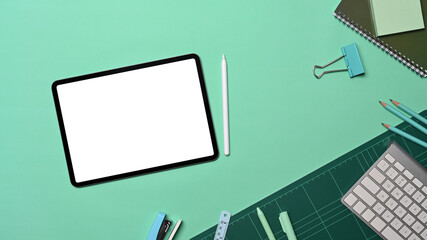 Mock up digital tablet and stationery on green background.