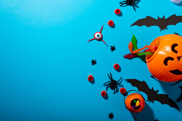 Close up view of multiple halloween candies and toys against blue background - Powered by Adobe