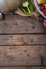 Close up of multiple food ingredients and cutlery with copy space on wooden surface