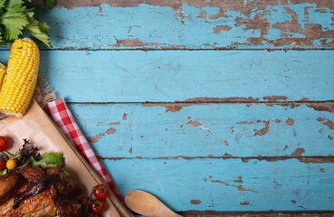 Cooked chicken and multiple food ingredients with copy space on blue wooden surface