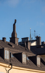 Fototapeta premium Black tin roofs and chimneys on buildings from 1700s in the old town Gamla Stan a sunny autumn day in Stockholm