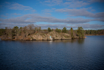 The cliff islet Fläsklösa in the lake Mälaren with a solar powered small lighthouse a sunny and color full autumn day in Stockholm