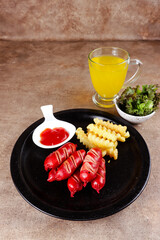 Sosis bakar. Grilled sausage with french fries and sauce.