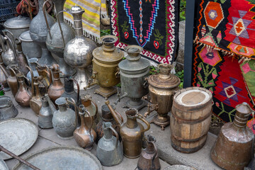 Assorted copperware and rugs on flea market
