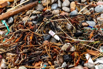 Spilled garbage on the beach of the big city. Empty used dirty plastic bottles. Dirty sea sandy shore the Black Sea. Environmental pollution. Ecological problem. Moving waves in the background