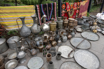 Assorted copperware and rugs on flea market