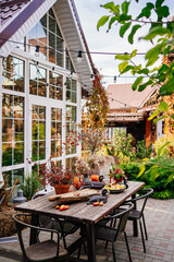 table in the backyard of the house decorated in autumn style. 
