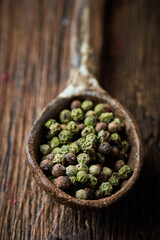 Green pepper on an ceramic spoon over wooden backround