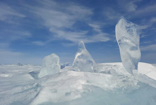 Clean ice of Lake Baikal. Winter when there is a lot of snow. 3 pieces of shining ice, like a festive ice sculpture.