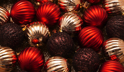 Luxury Christmas decorative composition with golden and red christmas balls on gold shiny background. Christmas or New Year concept. Festive background with baubles and copy space