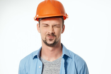 man in orange helmet blueprints builder light background