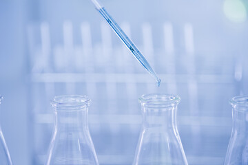 Doctor or scientist using pipette to drop a sample to test tube in medical research lab or science laboratory