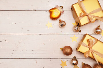  Christmas decorative composition with gold shiny snowflakes, christmas golden balls, gift boxes on rustic white wood background. Christmas or New Year concept. Festive Christmas