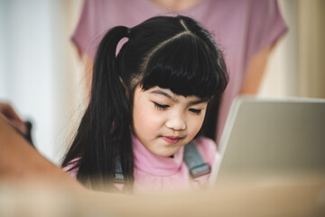 Asian children learning from home, homework learning with father and mother together in daughter family by laptop technology people, happy girl in online education lifestyle