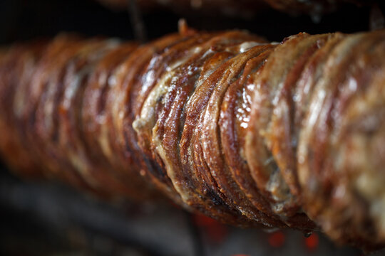 Kokorech, lamb intestines and giblets are cooked on spit, bokeh selective focus.