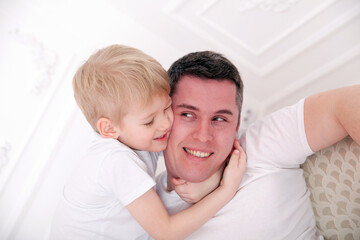 Fototapeta na wymiar Happy father and son in bright home interior.