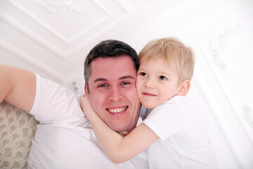 Fototapeta na wymiar little son of six hugging his dad at home.