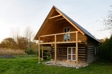 Wooden house renovation with balcony and attic. Reconstruction of old house construction