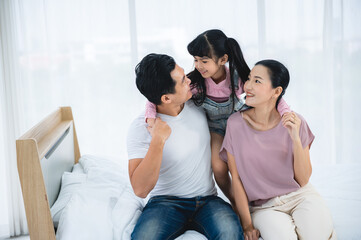 happy love family lifestyle with Asian father and mother and child daughter at home together