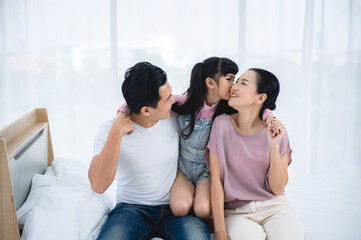 Fototapeta na wymiar happy love family lifestyle with Asian father and mother and child daughter at home together