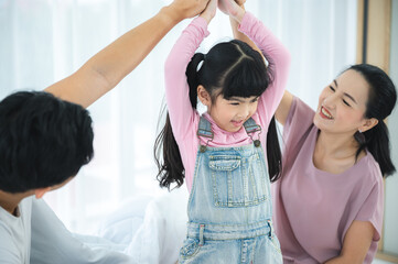 Fototapeta premium happy love family lifestyle with Asian father and mother and child daughter at home together