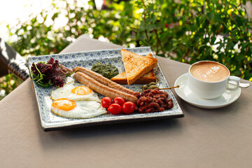 Served english breakfast with cappuccino coffee in terrace cafe