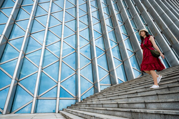 Asian woman in red dress at modern building, female girl with urban city lifestyle © chokniti