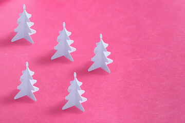 Naklejka na ściany i meble White metal Christmas trees on pink background. Minimalist pattern festive background.