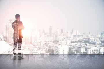 Back view of young european man standing on abstract rooftop white city background with mock up place. Success and leadership concept. Double exposure.