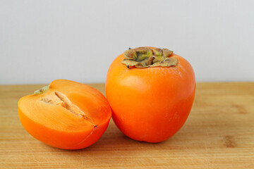 Ripe juicy persimmon on a wooden background
