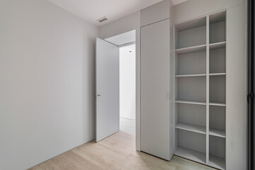 Interior of gray room with wardrobe and empty shelves. Refurbished apartment before settling of new tenants