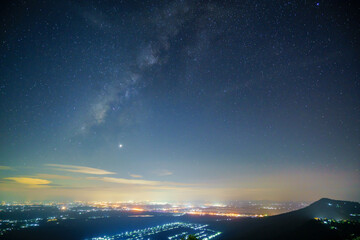 Panorama view universe space shot of milky way galaxy with stars on night sky background at mountains and city light landscape Thailand