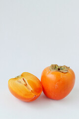 Ripe juicy persimmon on a white background