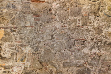 Fragment of old stone wall. Multicolored large cobbles. Old medieval castle stone wall texture background.