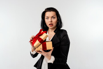 Fototapeta premium Curious businesswoman in black formal suit jacket opened gift box decorated with red ribbon. Holidays, celebration and lifestyle concept