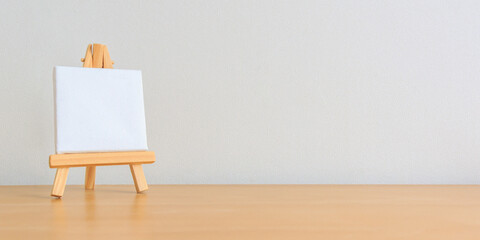 one small blank canvas on tiny wooden easel