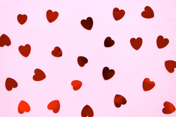 Red hearts shiny confetti on pink background, frame of hearts pattern
