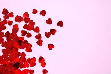 Red hearts shiny confetti on pink background, frame of hearts with space 